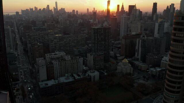 High angle view of town development. Tilt up reveal of skyline against setting sun. Manhattan, New York City, USA