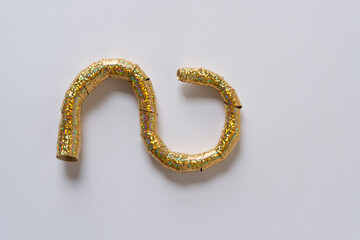 gold, metallic glitter ribbon or streamer, tightly coiled, and paper