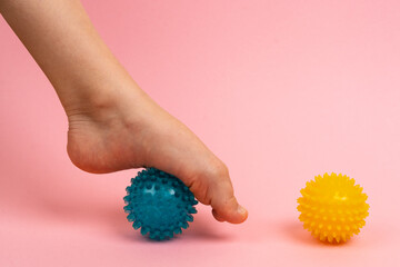 blue and yellow needle ball for massage and physical therapy on a pink background with a child's...