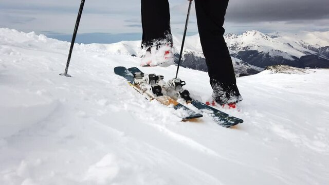 Close up of skier putting on winter skis and boots, detailed view of the ski bindings concept in sunny day