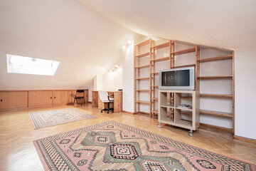 Upstairs loft of a single-family residential home with wooden shelving and rugs