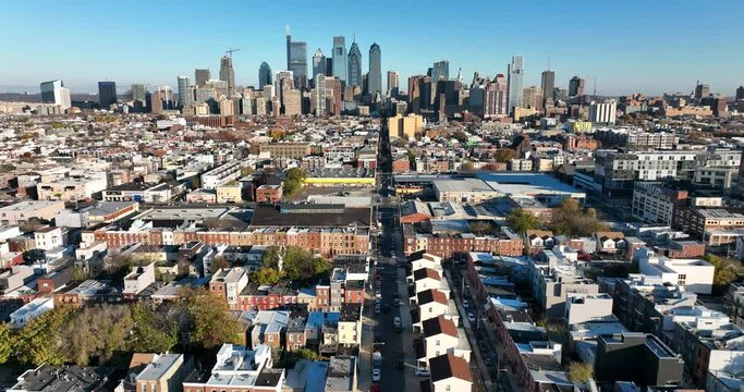 Dramatic aerial establishing shot of Philadelphia. Residential neighborhoods and cityscape skyline in distance.