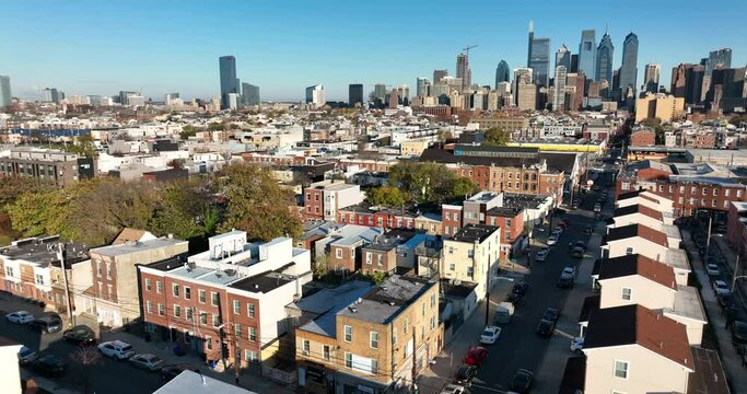 Aerial reveal shot of residential neighborhood and Philadelphia American city skyline. Beautiful golden hour light.