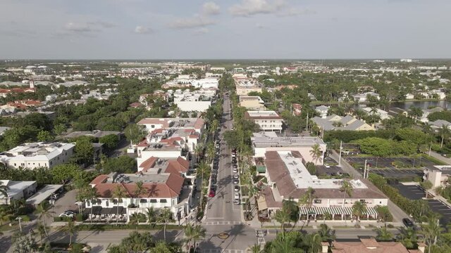 Aerial follows quiet palm lined Fifth Ave in sunny Naples, Florida