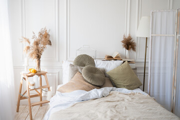Stylish interior of comfortable bedroom. Scandinavian bedroom interior. Cozy apartment in soft beige and white colors