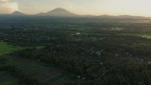 Tropical Ubud town hidden in jungle landscape of Bali with view of Mount Agung and Abang