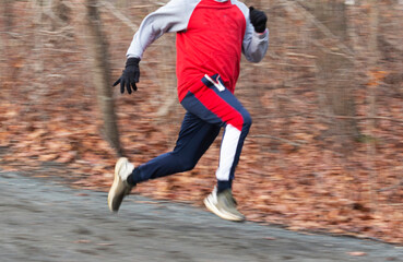 Fototapeta na wymiar Fast runner running downhill in the woods with a blurred background
