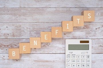 「BENEFITS」と書かれた積み木と電卓
