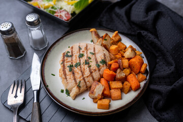 Grilled chicken breasts dinner with roasted carrots and sweet potato. Healthy low calorie meal. Calorie counting food.
