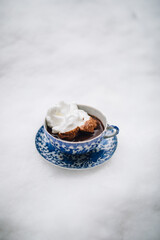 Fototapeta na wymiar hot chocolate in blue and white Japanese teacup and saucer topped with meringue sitting outside in the snow