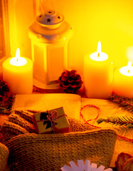 composition of a cozy christmas evening on the window with candles, a gift and a warm sweater