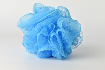 Exfoliating device in the shower Made from blue plastic fibers. on a white background