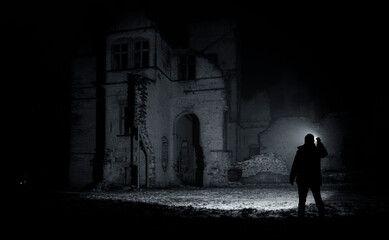 a man with a flashlight near the ruins of an old castle