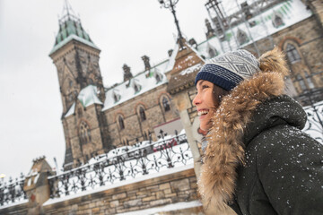 Ottawa winter city Asian woman walking by Canadian Parliament in Ontario, Canada. Travel tourist...