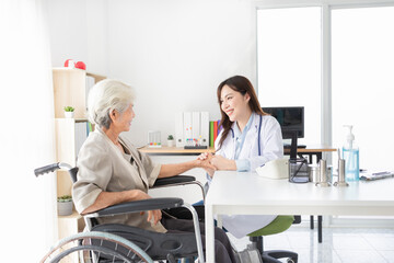 asian female doctor holding hand of old patient in mental health clinic, patient have a problem health , hand in hand, elderly healthcare promotion