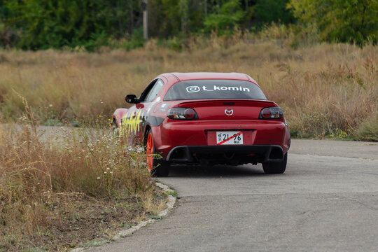 Red sports car. The Mazda RX8 goes down the road at high speed.