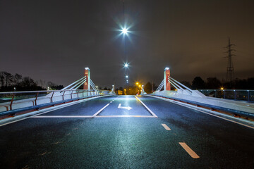 Bridge with busy street and traffic lights at night