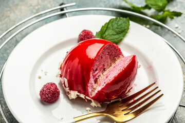 Round cake Raspberry dessert in red glaze, Delicious raw vegan volcano cakes made from fermented cashew mousse, with raspberry jam