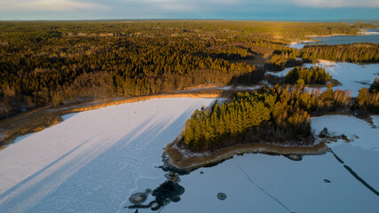 Aerial view of little Swedish village with islands and forests on a Baltic sea coast at winter time. Drone photography - winter in Gavleborg County, Axmar Burk Sweden