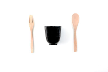 A black glass with wooden fork and spoon isolated in a white background
