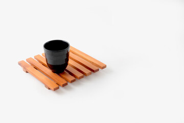 A black glass upon wooden placemat