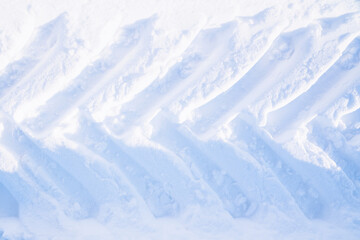 Traces of tractor wheels in the snow. The imprint of the tread of municipal services equipment during snow clearing. Top view