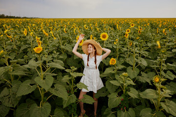 woman with pigtails In a field with blooming sunflowers landscape