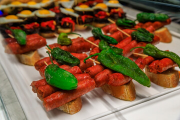 Spanish pintxos of sausages with peppers in a Basque bar, San Sebastian, Spain