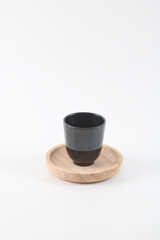 A plastic cup on a wooden tray.