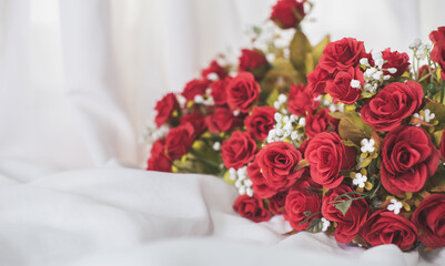 Romantic still life, Red roses on a silk white putty background. Fragrant red flowers, gift concept for Valentine's Day, Wedding or Birthday. Soft focus. any day to say I love you. red for Chinese new