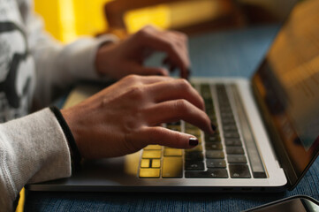 Close up de manos de mujer trabajando en laptop desde casa
