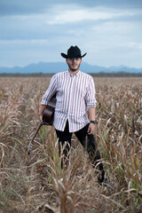 JOVEN MEXICANO CANTANDO CON SU GUITARRA USA SOMBRERO Y TIENE BARBA