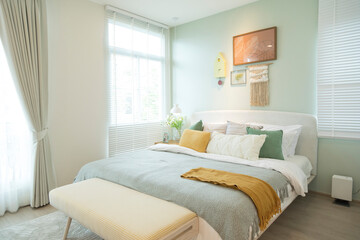 Stylish bedroom with modern green and yellow pillow and furniture. Interior design