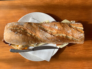CHEESE, BACON AND FRIED EGG SANDWICH ON A WOODEN TABLE