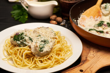 Portion of delicious meatballs with spinach in a creamy sauce