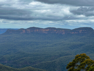 Blue Mountains with view of dark clouds covering the rainforest trees, Sydney Australia.