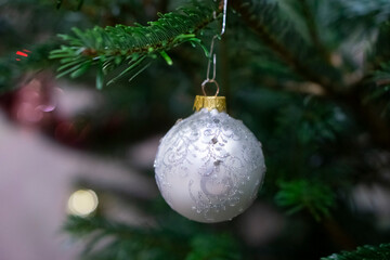 Closeup of Festively Decorated Christmas tree with beautiful toys
 on blurred fir fairy background. Defocused garland lights, Bokeh effect. Christmas background - baubles and branch of spruce tree.