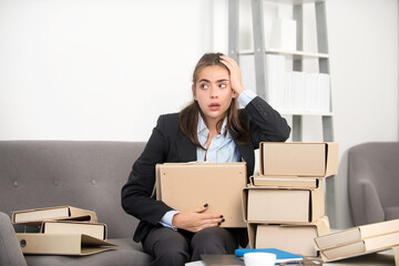 Busy business woman with many folders of documents, secretary girl working alone late in office. Angry sad secretary, upset accountant employee.