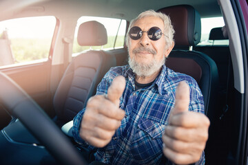 Happy hipster senior man pensioner smiling and driving car