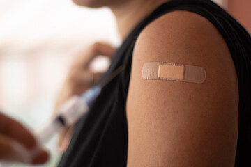 Covid-19 vaccination done. Vaccine concept. Smiling caucasian woman, closeup of arm. Coronavirus pandemic period