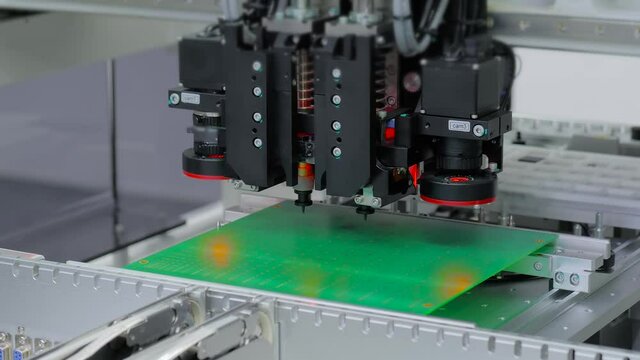 Assembly of printed circuit board - automatic SMT pick and place machine installing SMD electronic components. Production, technology, industrial, robotic and manufacturing concept