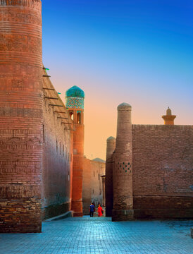 Beautiful view of ancient Itchan Kala fortress at early morning, against the background of bright sunrise sky in Historic Center of Khiva (UNESCO World Heritage Site), Uzbekistan, Central Asia