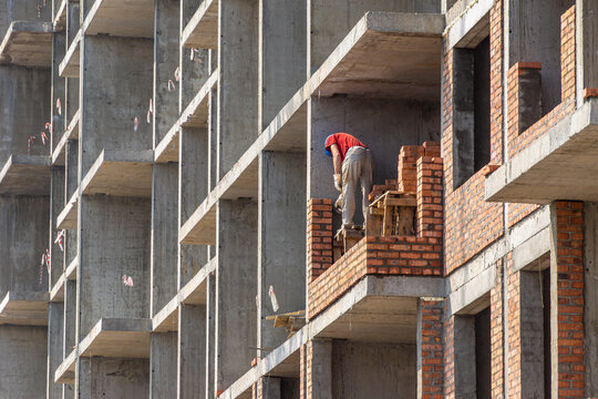 Erection of internal partitions and external walls of a monolithic frame building from bricks