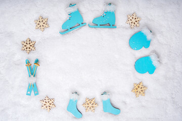 Sports set with bright blue wooden toys skates, skis, sledges and wooden snowflakes in the shape of...