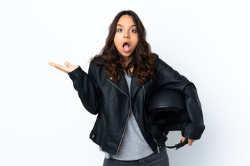 Fototapeta premium Young woman holding a motorcycle helmet over isolated white background making phone gesture and doubting