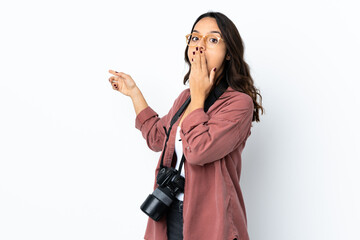 Young photographer woman over isolated white background with surprise expression while pointing side