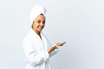 Young woman in bathrobe over isolated white background extending hands to the side for inviting to come