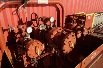 Bunker station with pipes and manifolds blinded with flanges ready to supply of diesel or heavy fuel to fuel tanks in container vessel situated from starboard and port sides on main deck.