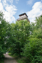 A high lookout tower made of white bricks in South Moravia in the town of Tisnov. Observation deck with wooden balcony in summer.