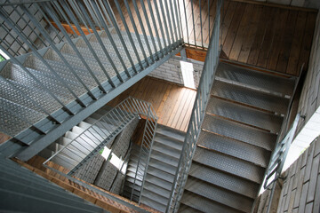 Steel staircase with wooden floor and white brick wall at the Kluacnina lookout tower in Tisnov in the Czech Republic. Modern architecture stair construction.